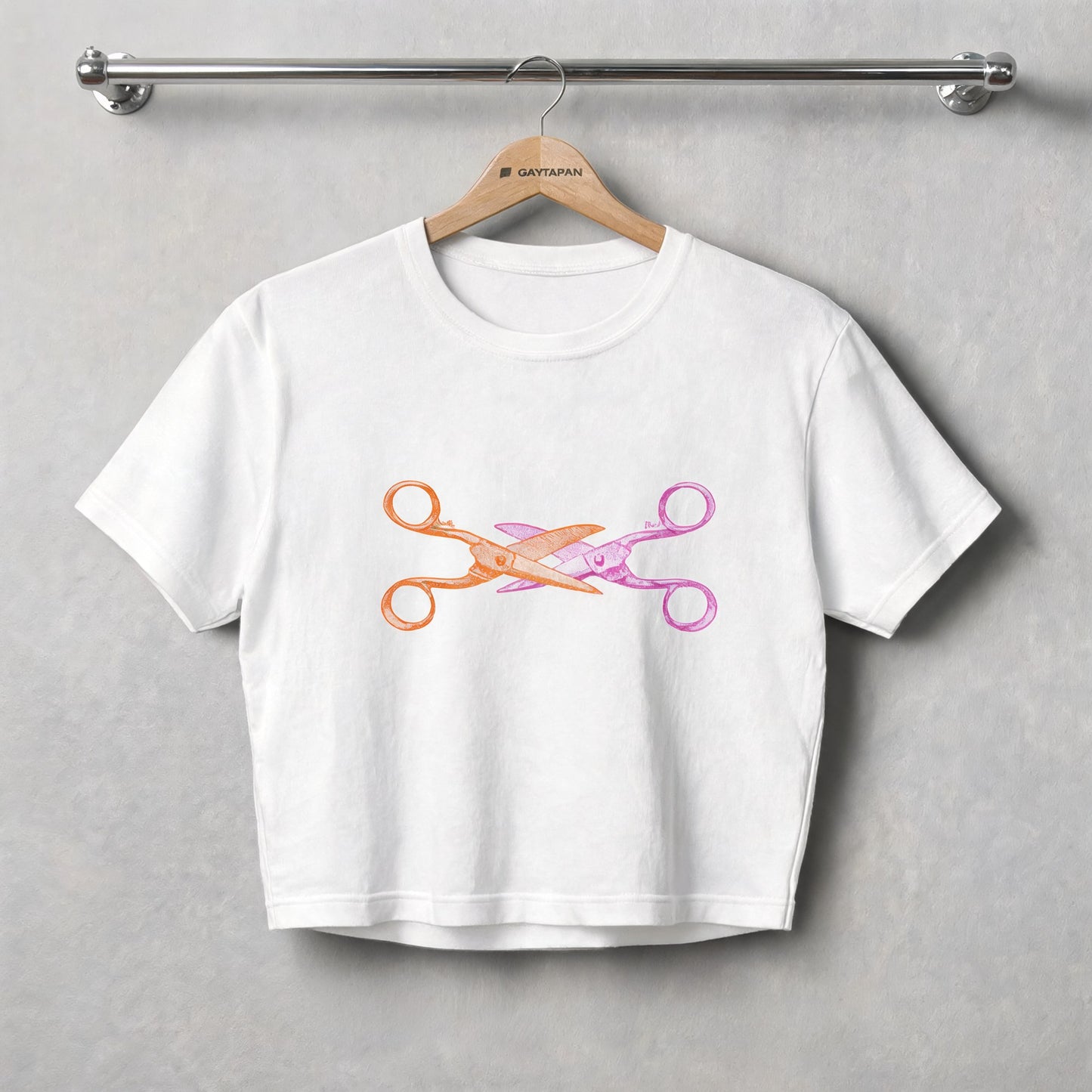 Crop top blanc à ciseaux croisés orange et rose, présenté sur un cintre GAYTAPAN