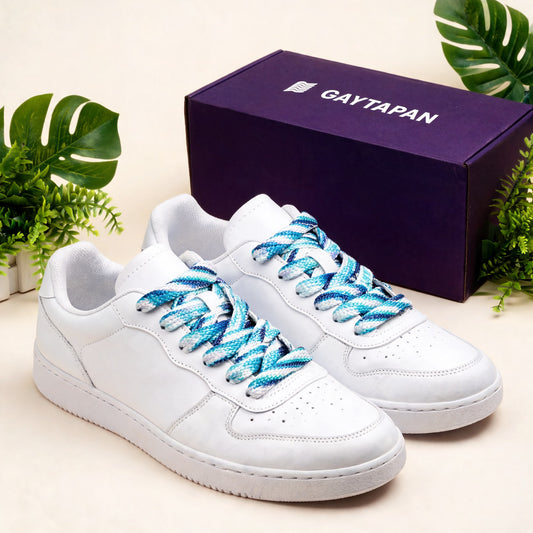 Lacets gay masculin verts et bleus lacés sur des baskets blanches, avec une boîte GAYTAPAN