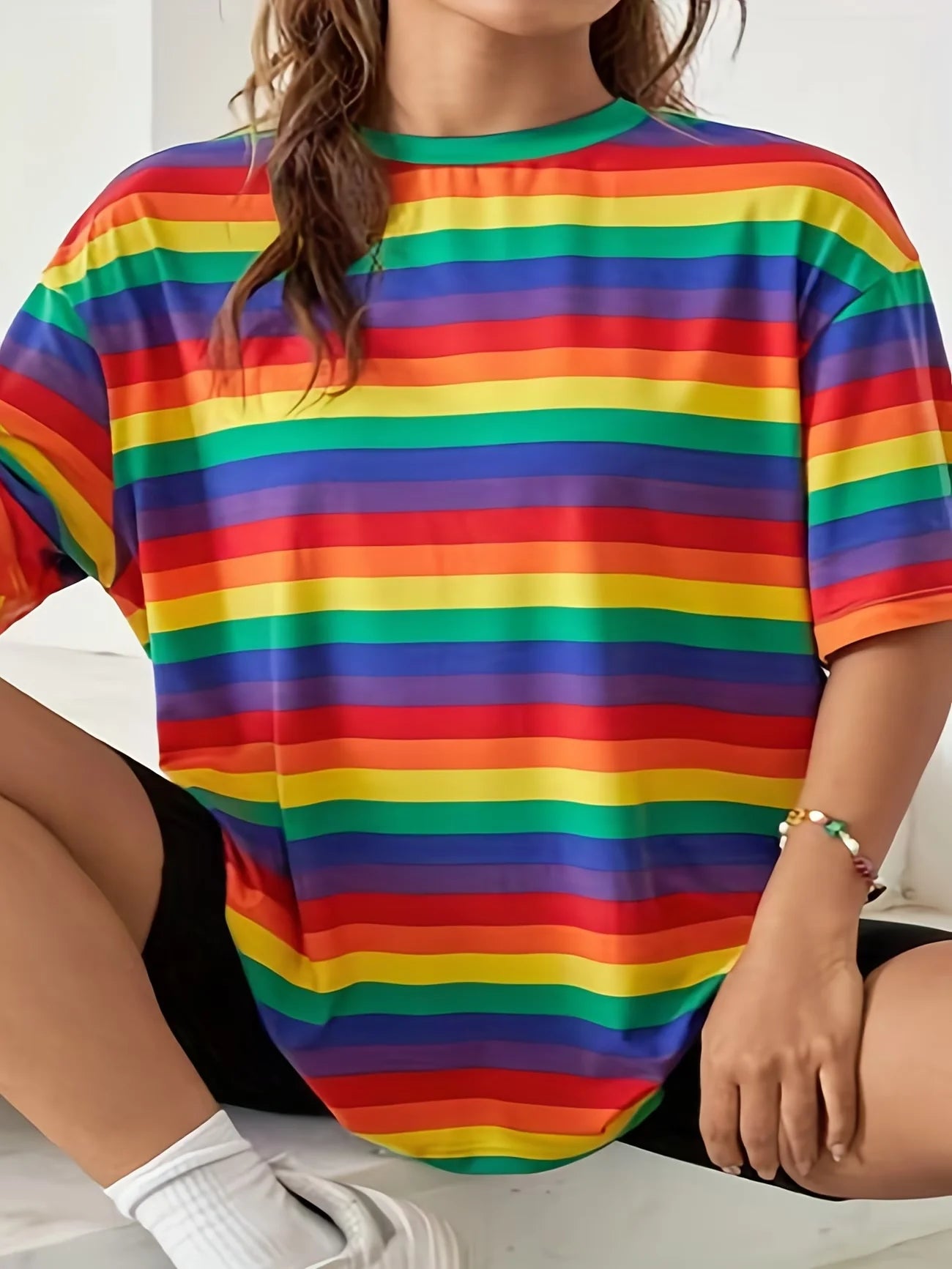 T-shirt oversize à rayures arc-en-ciel horizontales, porté avec un short noir