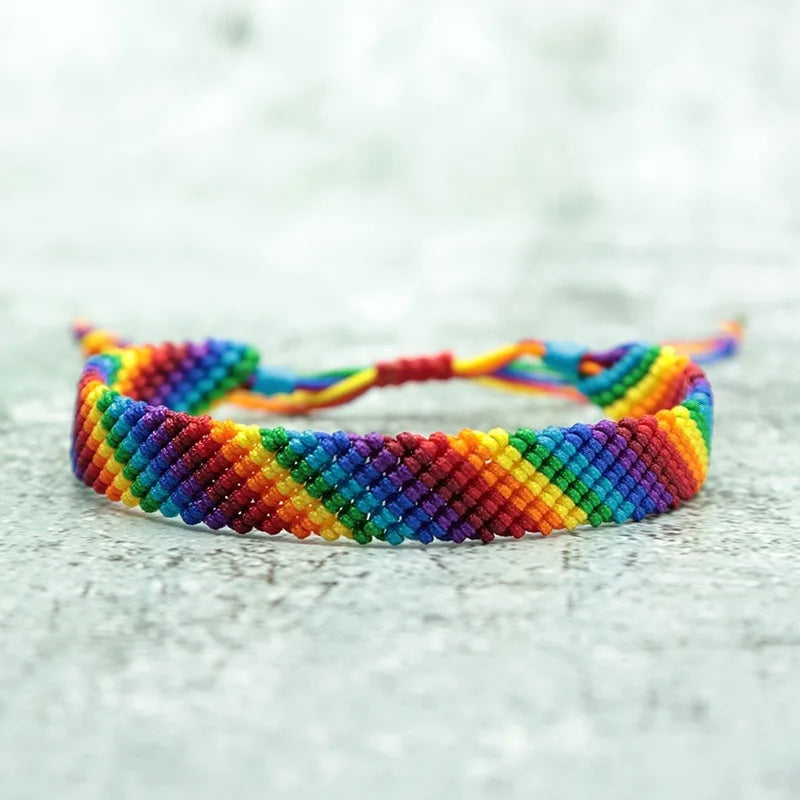Bracelet LGBT tressé à la main aux couleurs de l'arc-en-ciel, posé à plat