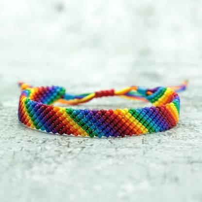 Bracelet LGBT tressé à la main aux couleurs de l'arc-en-ciel, posé à plat