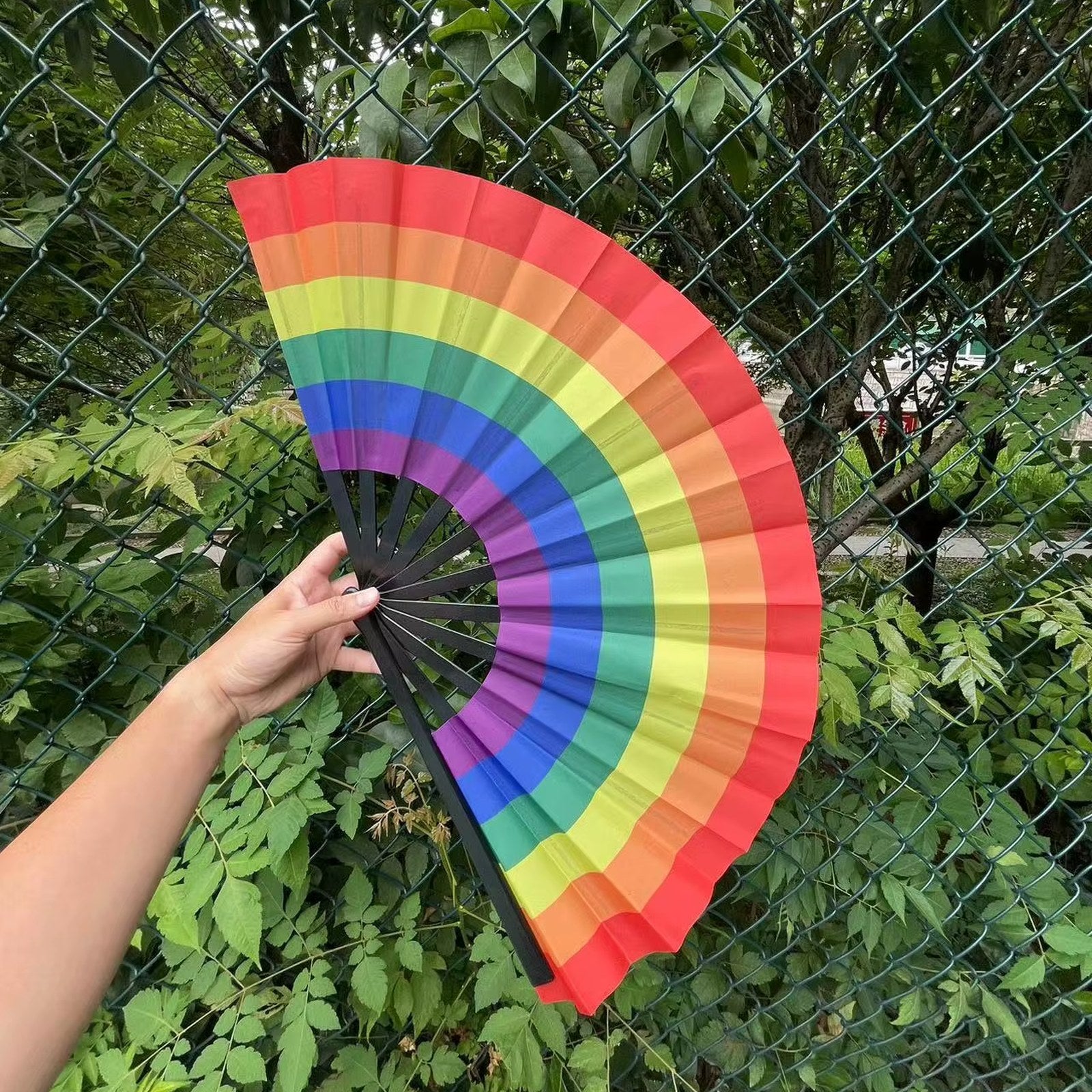 Éventail LGBT arc-en-ciel de 64 cm tenu à la main et déplié en extérieur