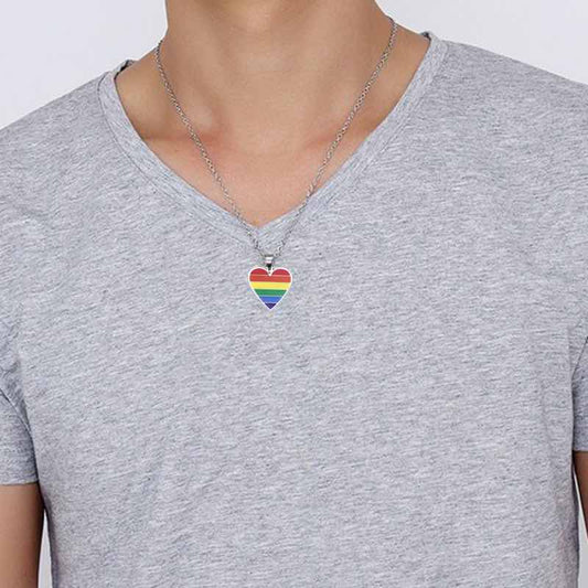 Le cœur arc-en-ciel porté sur un t-shirt gris à col V