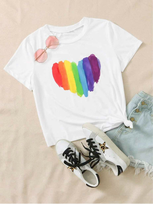 Le t-shirt au cœur arc-en-ciel posé à plat avec un jean et des baskets